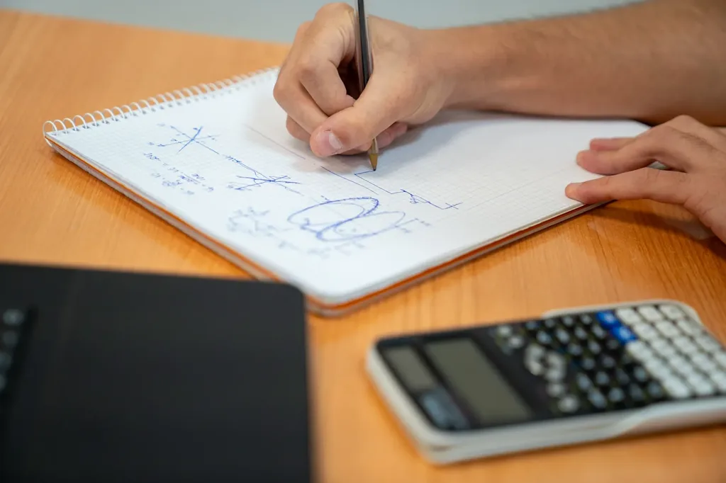 Estudiante planificando su estudio con cuaderno y calculadora